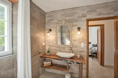 a bathroom with a sink and a mirror at LA SOURCE 4 chambres in Valle d'Alesani