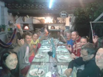 a group of people sitting around a long table at Autour du Hamac chambres et table d'hôtes in Moltifao