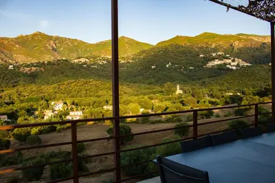 a room with a view of a mountain range at APICULTEUR in Oletta