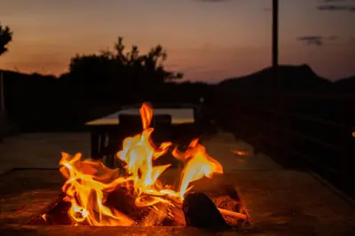 a fire burns in a fire pit at sunset at APICULTEUR in Oletta