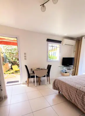 a bedroom with a bed and a table and chairs at Chambre d'hôte Kalango proche de la plage-Piscine in Lucciana