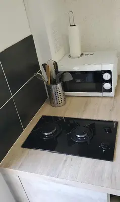 a microwave sitting on top of a stove in a kitchen at Chambre d'hôte Kalango proche de la plage-Piscine in Lucciana