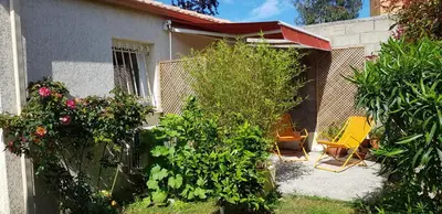 a garden with a patio with chairs and plants at Chambre d'hôte Kalango proche de la plage-Piscine in Lucciana