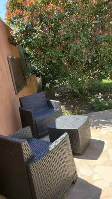 a group of chairs and tables and a tree at Chambre d'hôte Kalango proche de la plage-Piscine in Lucciana