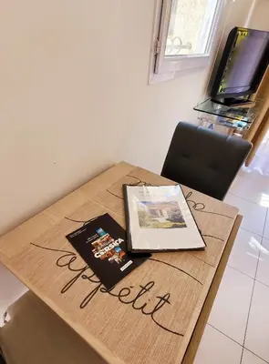 a wooden table with a laptop on top of it at Chambre d'hôte Kalango proche de la plage-Piscine in Lucciana