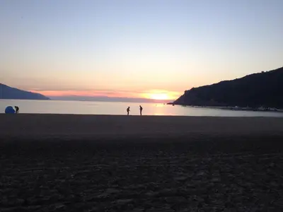 two people walking on the beach at sunset at Les Maisonnettes de Lava - Golfe de Lava - APPIETTO in Appietto