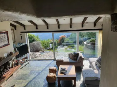 a living room with a view of a large window at maison de charme avec piscine et vue exceptionnelle in Scolca