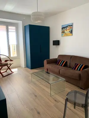 a living room with a couch and a glass table at Grand studio rue piétonne Ajaccio in Ajaccio