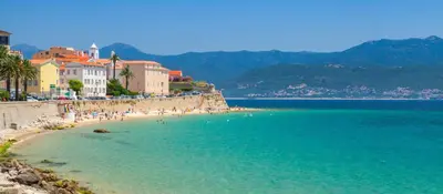 a beach with a group of people in the water at STUDIO rue pietonne Ajaccio in Ajaccio