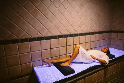 a man laying on a bed in a shower stall at Domaine Naturiste de Riva Bella in Linguizzetta