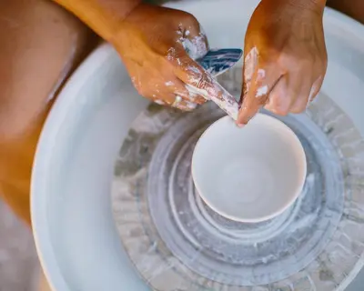 a woman washing her hands on a pottery wheel at Domaine Naturiste de Riva Bella in Linguizzetta