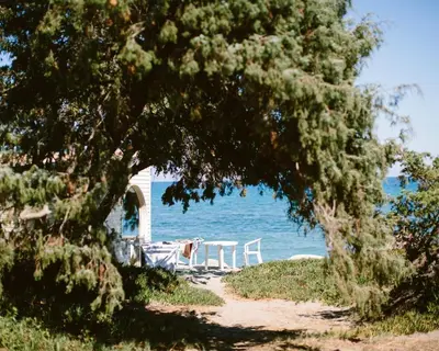 a table and chairs sitting next to the water at Domaine Naturiste de Riva Bella in Linguizzetta