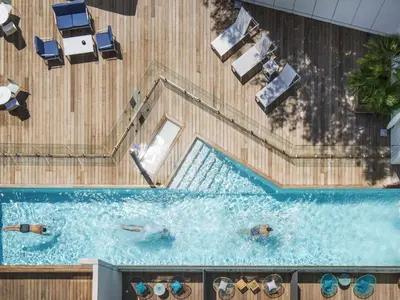 an overhead view of a swimming pool with people in it at Mercure Ajaccio in Ajaccio