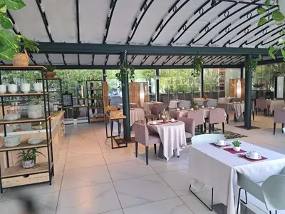 a restaurant with white tables and chairs and a ceiling at Mercure Ajaccio in Ajaccio