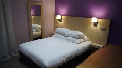 a bedroom with a bed with white sheets and pillows at Auberge du cheval blanc in Ajaccio
