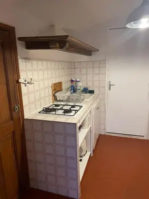 a small kitchen with a stove top oven at Auberge du cheval blanc in Ajaccio