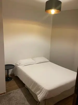 a bedroom with a white bed and a lamp at Auberge du cheval blanc in Ajaccio