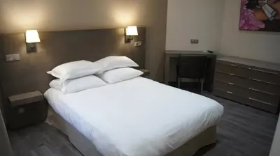 a bedroom with a large bed with white sheets and pillows at Auberge du cheval blanc in Ajaccio