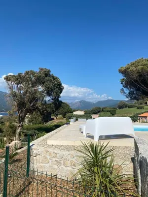a white couch sitting on a stone path next to a pool at Résidence Figarella in Propriano