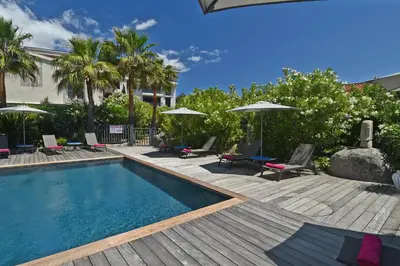 a swimming pool with chairs and umbrellas in a yard at Golfe Hôtel & Spa Porto-Vecchio in Porto-Vecchio