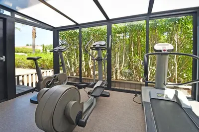 a gym with three elliptical machines and a window at Golfe Hôtel & Spa Porto-Vecchio in Porto-Vecchio