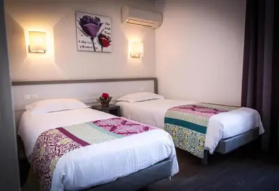 two beds in a hotel room with white walls at Golfe Hôtel & Spa Porto-Vecchio in Porto-Vecchio