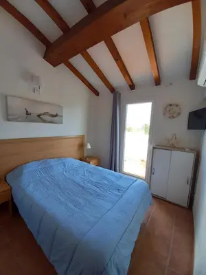 a bedroom with a blue bed and a window at Appartement avec piscine vue mer et montagne in San-Nicolao