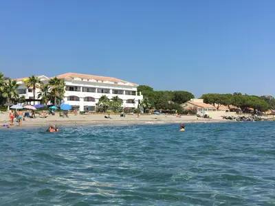 a group of people in the water at a beach at Appartement avec piscine vue mer et montagne in San-Nicolao