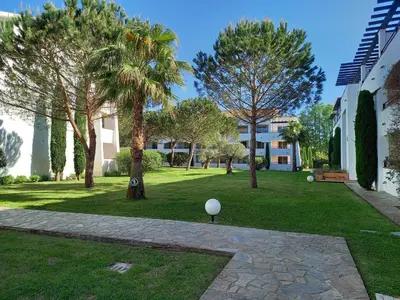 a park with palm trees and a building at Appartement avec piscine vue mer et montagne in San-Nicolao