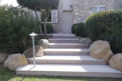 a set of stairs leading to a house with rocks at Villa Le Lagon - Vision Luxe in Bonifacio