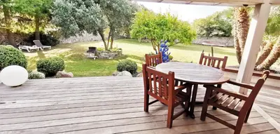 a wooden table and chairs on a wooden deck at Villa Le Lagon - Vision Luxe in Bonifacio