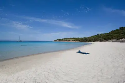 a white sandy beach with a boat on it at Villa Le Lagon - Vision Luxe in Bonifacio