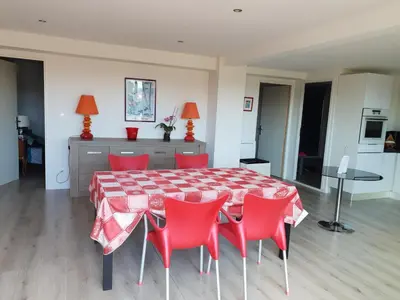 a dining room with a table and red chairs at Le rocher in Porticcio