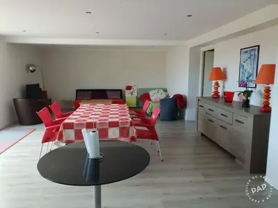 a living room with a table and red chairs at Le rocher in Porticcio