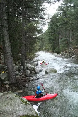 a group of people in a red kayak on a river at L'Acqua Viva in Calacuccia