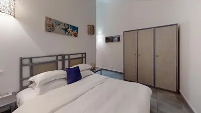 a bedroom with a large white bed and a closet at Poisson Rouge in Bonifacio