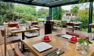a restaurant with wooden tables and chairs on a deck at Poisson Rouge in Bonifacio