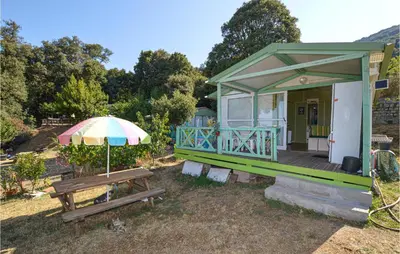 a small house with a bench and an umbrella at Nice Stacaravan In Casalabriva in Casalabriva