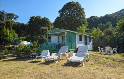 a group of chairs and an umbrella in front of a house at Nice Stacaravan In Casalabriva in Casalabriva