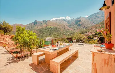 a table on a patio with a view of mountains at Nice Home In Feliceto in Feliceto