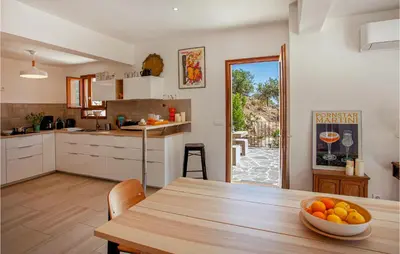 a kitchen with a table with a bowl of oranges on it at Nice Home In Feliceto in Feliceto