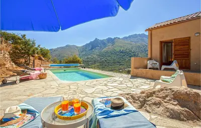 a villa with a swimming pool and a blue umbrella at Nice Home In Feliceto in Feliceto