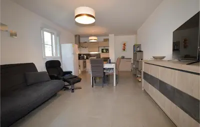 a living room and kitchen with a couch and a table at Amazing Apartment In Moriani Plage in Moriani Plage
