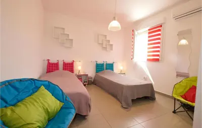 a bedroom with two beds and a window at Amazing Apartment In Moriani Plage in Moriani Plage