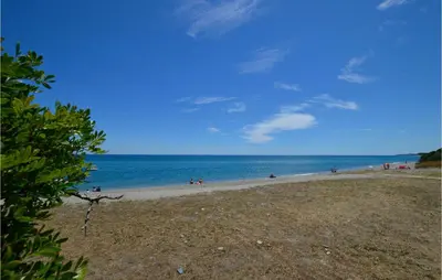 a group of people on a beach near the water at Amazing Apartment In Moriani Plage in Moriani Plage