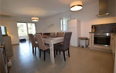 a kitchen and dining room with a table and chairs at Amazing Apartment In Moriani Plage in Moriani Plage