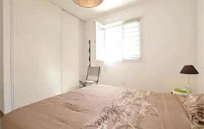 a white bedroom with a bed and a window at Amazing Apartment In Moriani Plage in Moriani Plage