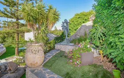 a statue in a garden with flowers and plants at Pet Friendly Apartment in Pianottoli-Caldarello