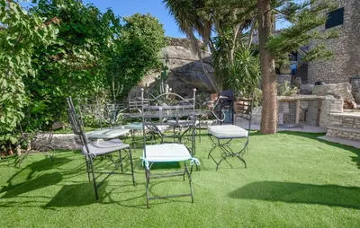 a group of chairs and a table in the grass at Pet Friendly Apartment in Pianottoli-Caldarello
