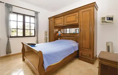 a bedroom with a large wooden bed and a window at Pet Friendly Apartment in Pianottoli-Caldarello